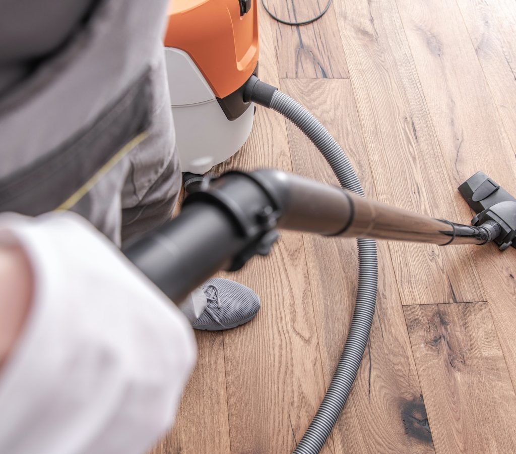 male-worker-vacuuming-hardwood-flooring-